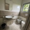 Bagno moderno con lavabo sospeso e finestra.