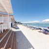 Passerella di legno lungo una spiaggia con lettini.