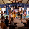 Bambini ballano sul palco con animatori.