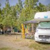 Camper parcheggiati in un'area campeggio con vestiti che asciugano vicino.