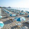 Ombrelloni bianchi e blu allineati sulla spiaggia.