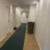 Corridoio d'albergo con moquette verde.