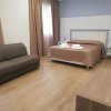 Camera d'albergo con letto, divano e tende marroni.
