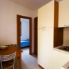 Cucina con tavolo e vista su camera da letto.