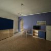 Sala con parete viola, tavolo e frigorifero.