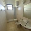 Bagno con doccia, lavandino e WC, finestra sopra.