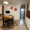 Cucina con tavolo e quattro sedie, TV a parete.
