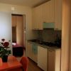 Interno cucina con tavolo arancione e fiori.