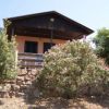 Una casa con veranda di legno e cespugli fioriti davanti.