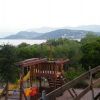 Un parco giochi in legno con vista su montagne e mare sullo sfondo.