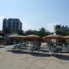 Spiaggia con lettini e ombrelloni colorati.