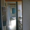 Interno di un bagno con doccia e lavandino, visibile attraverso una porta aperta.