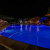 Piscina illuminata di notte con giochi d'acqua.