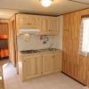 Cucina in legno chiaro con fornello, lavello e armadietti, luce naturale.