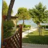 Vista dal cortile con prato, alberi e accesso a un lago.