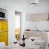 Cucina moderna con frigorifero giallo e tavolo da pranzo apparecchiato.
